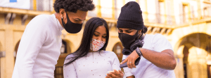 Local de prova Enem: Jovens de mascara conferindo algo no celular.