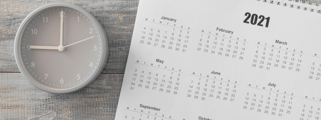 Cronograma Sisu: calendário ao lado de um relógio, sobre uma mesa.